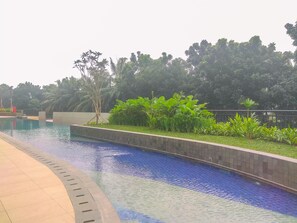 Relax by the serene pool surrounded by lush greenery and a variety of plants.