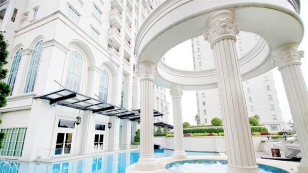 A luxurious indoor pool area with classical architecture, including white columns and arched windows. - Spacious And Modern Look 3Br Bellezza Apartment (Jakarta)