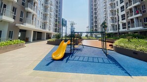 A playground with a yellow slide and a climbing structure in a residential area with high-rise buildings. - Affordable And Homey Studio At Tokyo Riverside Pik 2 Apartment (Teluknaga)