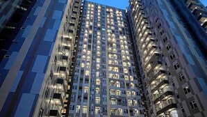 Un edificio alto con varios pisos, cada uno con numerosas ventanas y balcones.