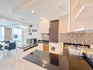 Apartamento Deluxe | Cocina privada | Frigorífico, placa de cocina, arrocera y mesa de comedor