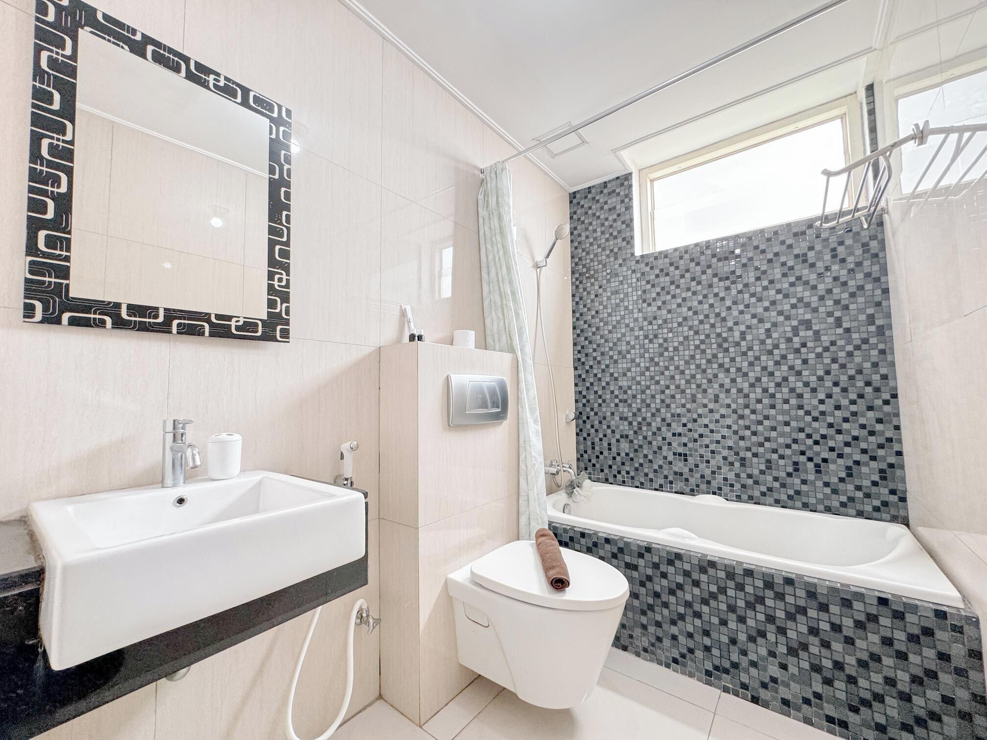A modern bathroom with a white sink, toilet, and bathtub.