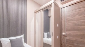 Una camera da letto con un letto, un armadio e un guardaroba con ante scorrevoli.