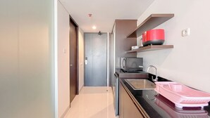 A modern kitchen with a sink, countertop, and a red pot on a shelf. - Modern Furnished Studio (No Kitchen) Apartment At Skales Residence Nusa Dua Bali (Nusa Dua)