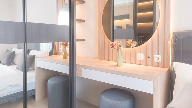 A modern bedroom with a bed, bedside table, and a round mirror. - Good Place And Comfy Studio At Anwa Residence Apartment (South Tangerang)