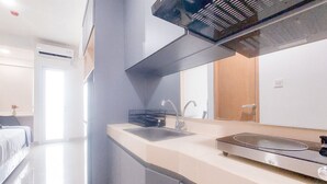 Eine moderne Küche mit Einbauherd, Spüle und einem großen Spiegel über der Arbeitsfläche.