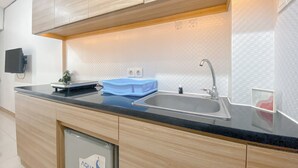 Una cocina moderna con armarios de madera, encimera negra, pileta de acero inoxidable y un ventanal.
