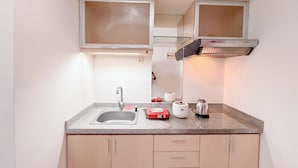 A compact kitchen with a sink, countertop, and cabinets. - Best Price And Comfortable Living Studio At High Point Serviced Apartment (Surabaya)