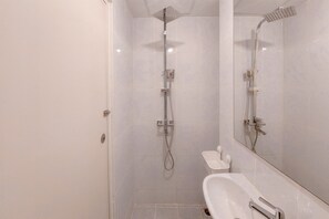 A modern bathroom with a shower, a sink, and a mirror. - Best Price And Comfy Studio At Tokyo Riverside Pik 2 Apartment (Teluknaga)