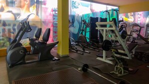 A gym with exercise equipment, large windows, and motivational posters.