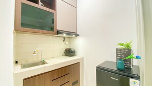 A compact kitchen with a sink, a toaster, and a refrigerator.