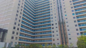 A high-rise building with multiple balconies and a central vertical feature.