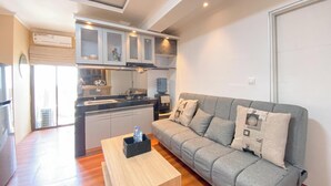 Une cuisine moderne dotée d’une cuisinière intégrée, de placards et d’un coin repas avec une table et un canapé en bois.