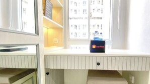 A small, compact room with a window, a shelf with a water bottle, and a travel bag on the window sill. - Cozy And Best Studio Apartment Tokyo Riverside Pik 2 (Teluknaga)