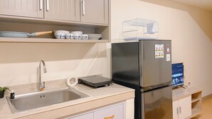 Una cucina moderna con lavello in acciaio inox, forno integrato e frigorifero con display digitale.
