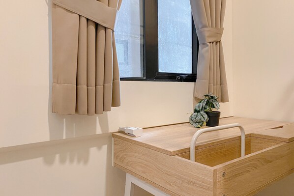 A bathroom with a wooden vanity, a window with beige curtains, and a potted plant on the counter. - Good Deal And Relaxing 3Br At Meikarta Apartment (Cikarang)