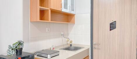 Eine moderne Küche mit Holzschränken, einer Spüle und einem Gerät von Sharp.