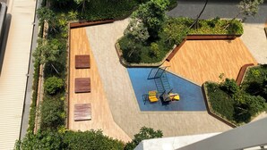 An aerial view of a courtyard with a basketball court, wooden benches, and surrounding greenery. - Brand New Studio Room At Tokyo Riverside Pik 2 Apartment (Teluknaga)