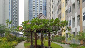 A garden area with a gazebo, surrounded by high-rise residential buildings. - Comfortable Studio At Podomoro City Deli Medan Apartment (Medan)