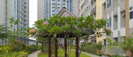 A garden area with a gazebo, surrounded by high-rise residential buildings.