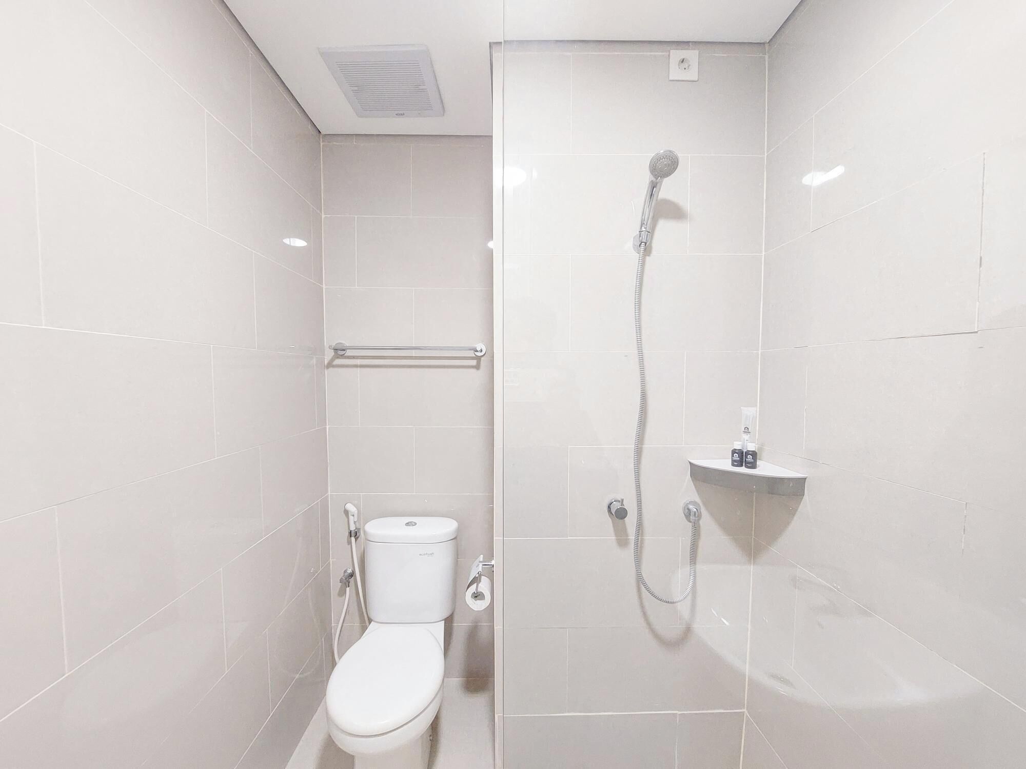 Un baño moderno con inodoro, ducha y secamanos.
