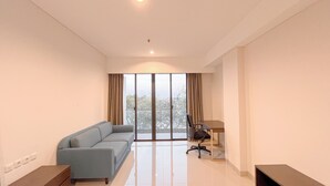A modern living room with a sofa, a desk, and a chair. - Studio Near Nusa Dua Convention Center Bali at Skales Residence (Nusa Dua)