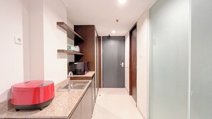 A modern kitchen with a red appliance, a sink, and a microwave. - Studio Near Nusa Dua Convention Center Bali at Skales Residence (Nusa Dua)