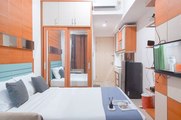 Relax in a stylish room with a comfortable bed, wall-mounted TV, and spacious wardrobe.