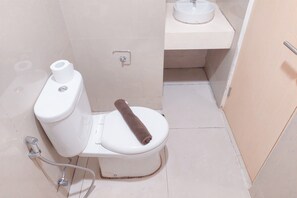 Bathroom features a toilet, shower, and sink with a towel provided.