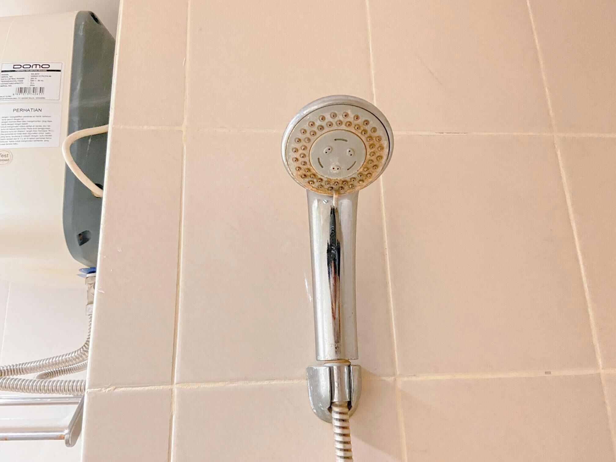 Un soffione dal design circolare con un tubo flessibile.
