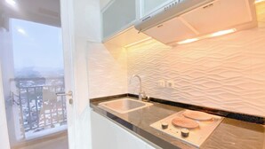 Cucina moderna con lavello doppio, forno integrato e vista sulla città attraverso una porta in vetro.