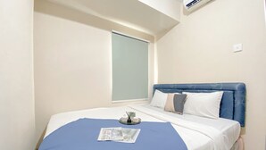 A bedroom with a bed, a window, and a wall-mounted air conditioner. - Good And Homey 2Br At Apartment Green Palm Residence (Jakarta)