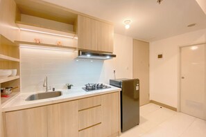 Apartamento Deluxe | Cocina privada | Frigorífico, placa de cocina, arrocera y mesa de comedor
