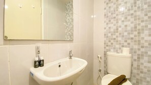 Enjoy a refreshing bathroom experience with a sink, mirror, and toilet, plus convenient toiletries at your fingertips.