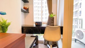 Ein modernes Hotelzimmer mit einem schwarzen Marmorschreibtisch, einem weißen Stuhl, einer kleinen Pflanze, einer Reisetasche und einem Schild mit aufgeführten Reisezielen.