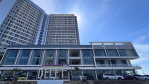 Un bâtiment moderne à plusieurs étages, doté de grandes fenêtres, qui semble être un espace commercial ou de bureaux.