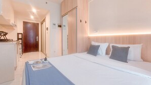 A hotel room with a bed, a desk, and a wardrobe.