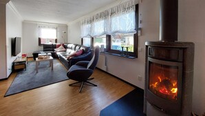 A living room with a sofa, a coffee table, and a fireplace. - 5 bedroom nice home in Västra Torup (Västra Torup)