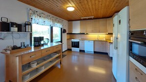 A modern kitchen with wooden cabinets, a built-in oven, a dishwasher, and a coffee maker on the counter. - 5 bedroom nice home in Västra Torup (Västra Torup)