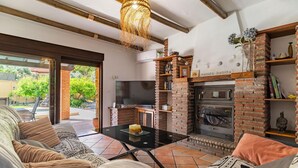 Un soggiorno accogliente con camino, televisione e una zona salotto confortevole.