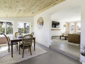 A modern interior with a dining area, a living room, and a fireplace.