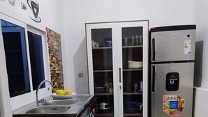 Een keuken met een inbouwoven, een koelkast en een kast met glazen deuren.