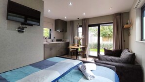 A modern bedroom with a large bed, a desk, and a kitchenette. - Nice home in Heinkenszand with WiFi (Heinkenszand)