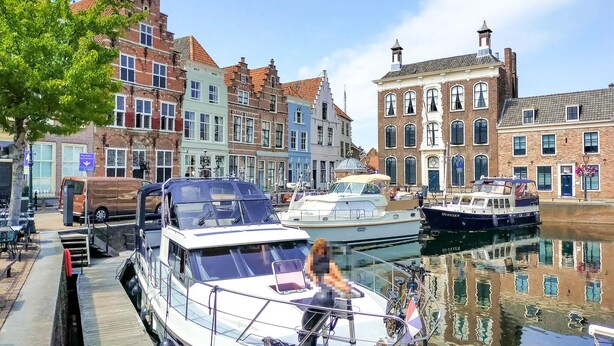 A canal with boats docked, surrounded by historic buildings with varied architecture. - Nice home in Heinkenszand with WiFi (Heinkenszand)