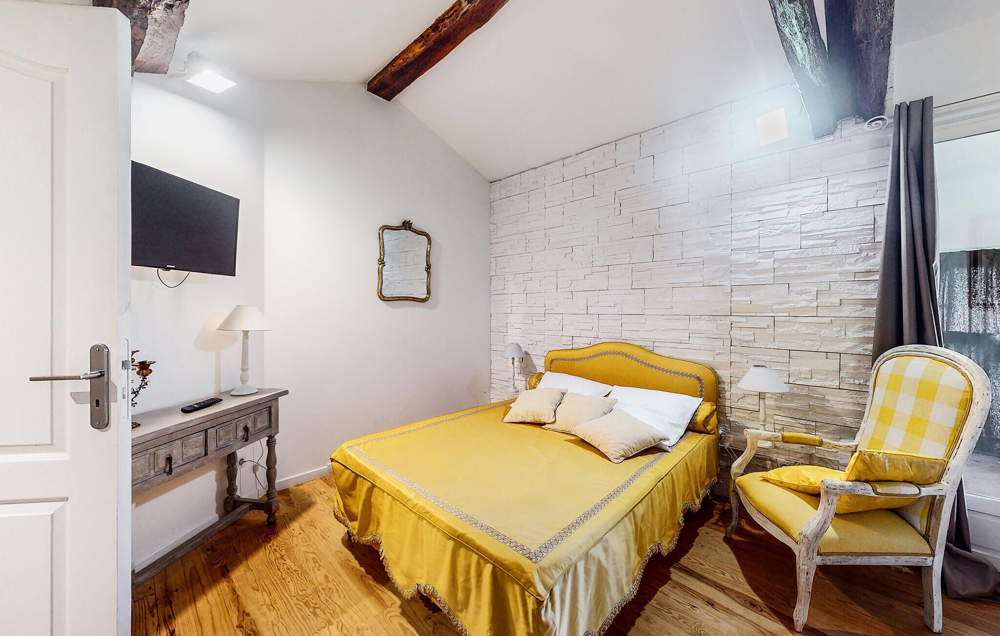 Une chambre à coucher avec un lit, une chaise, une commode et un miroir.