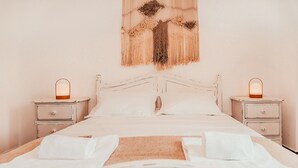 A neatly made bed with white linens, two bedside tables with lamps, and a wall hanging. - Altura Beach Villa by GT House (Castro Marim)