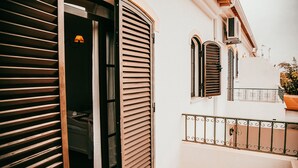 A building with a balcony, a door with shutters, and a small window with shutters. - Altura Beach Villa by GT House (Castro Marim)