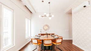 A dining area with a round table, six chairs, and a chandelier. - Elegant & Sophisticated by GT House (Lisbon)