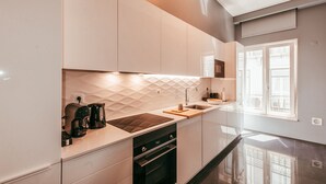A modern kitchen with a built-in oven, a coffee maker, and a sink. - Elegant & Sophisticated by GT House (Lisbon)