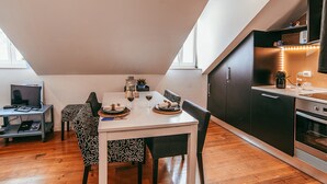 A compact kitchen with a dining area, a small table, and a computer desk. - Central & Typical Lisboa by GT House (Lisbon)